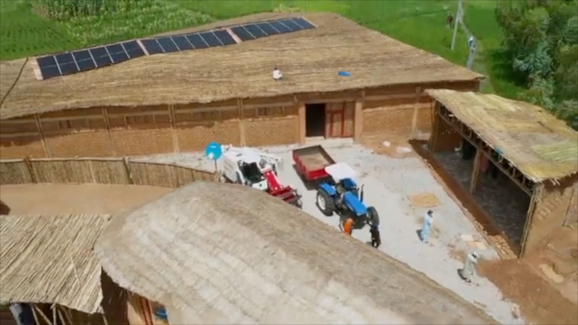Aerial view of an operating PULSE site in Northern Nigeria — rooftop solar, retail floor below, surrounding settlement at the edges.